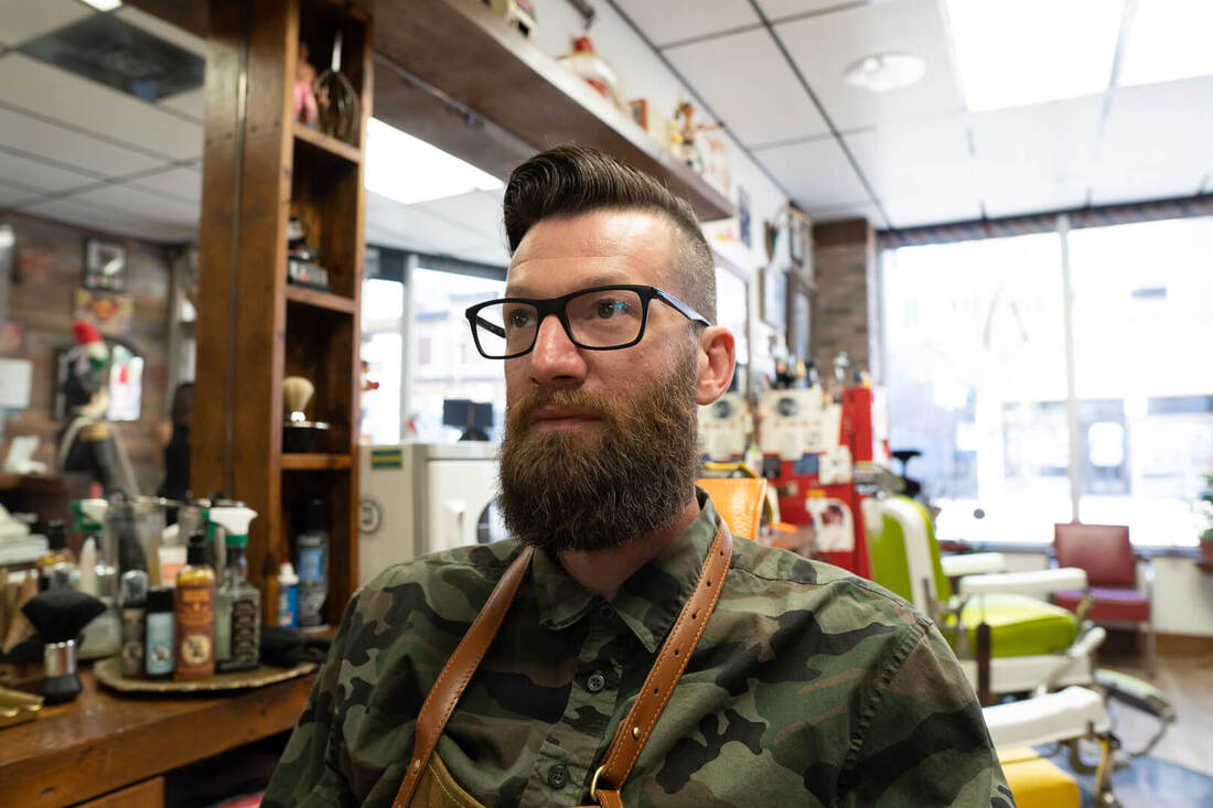 Jonah Grant, barber in Niagara Falls, Ontario in a barber chair