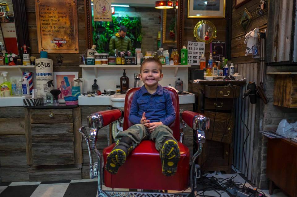 Cute kid in barber chair at Back Alley Barber Shop in Niagara Falls
